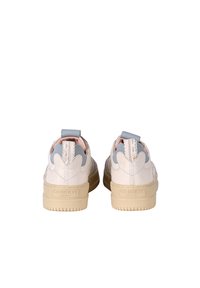 Sneakers in pelle bianca con design minimalista, accenti grigio chiaro e suola beige, dotati di un laccio sul retro e dettagli di cucitura sottili.