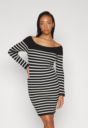 Off-shoulder kjole i svart og hvitt stripet mønster, ribbet tekstur, tettsittende design, lange ermer, kne-lengde med horisontale striper.