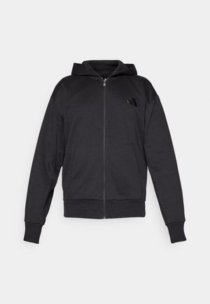 Fleece preto com fecho éclair, mangas longas, bolsos frontais, punhos e bainha canelados, e um pequeno logótipo no lado esquerdo do peito.