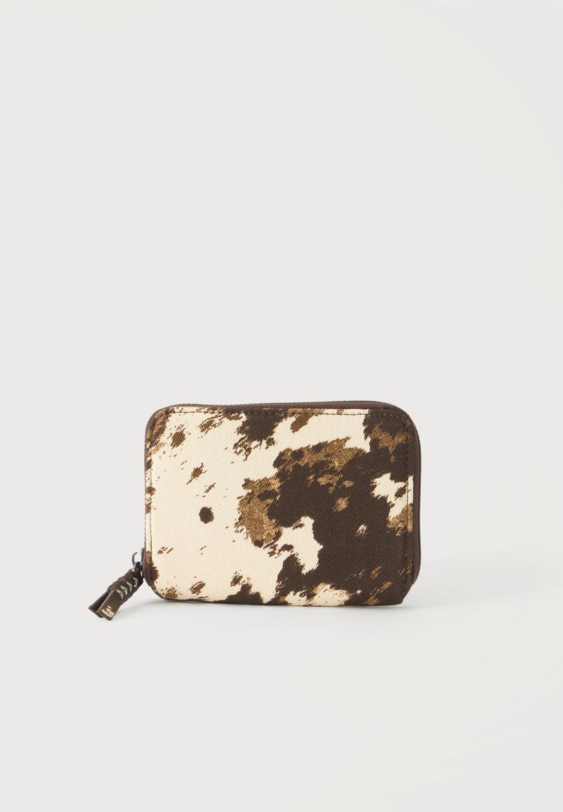 Petit portefeuille rectangulaire zippé avec motif en peau de vache marron et blanc sur fond blanc uni.