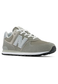 Baskets New Balance grises avec des matériaux en daim et en mesh, lacets blancs, accents gris, col rembourré et semelle texturée pour une meilleure adhérence.