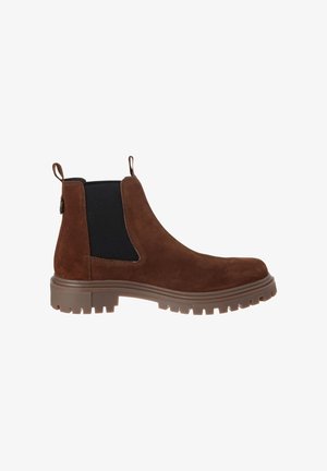 Stivale Chelsea in camoscio marrone con pannello elastico laterale nero, tiranti e suola in gomma spessa, mostrato di profilo su sfondo bianco.