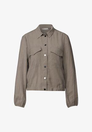 Veste taupe clair avec un col, fermeture à boutons, deux poches poitrine et poignets élastiques. Tissu lisse avec une texture légèrement brillante.