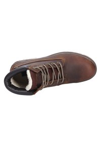 Botas de cuero marrón con puntera redonda, cuello acolchado y ojales de metal. Forradas con material suave y cuentan con cordones texturizados.