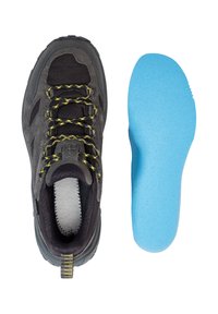 Schwarzer Wanderschuh mit grauen Akzenten und gelben Schnürsenkeln, zeigt strukturiertes Mesh und Gummisohle; daneben liegt eine blaue Einlegesohle.