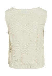 Lace linne i off-white med blommönster, öppen stickad textur och rund halsringning. Bakifrån syns en bohemisk design.