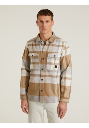 Camicia a quadri marrone e grigia con due taschini sul petto e bottoni neri. Realizzata in tessuto testurizzato, presenta blocchi di colore a contrasto.