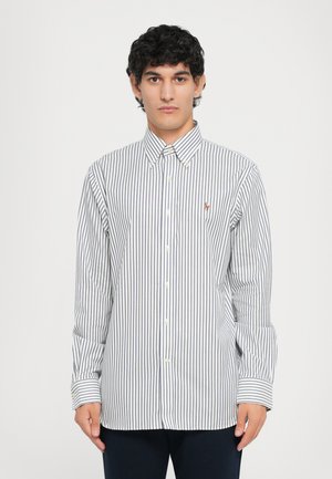 Overhemd met verticale marineblauwe en witte strepen, lange mouwen en een puntige kraag. Klein logo geborduurd op de borst.