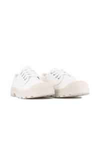 Zapatillas de lona blancas con suelas de goma blancas, puntera redonda, diseño con cordones y ojales plateados. Textura suave con un estilo minimalista.