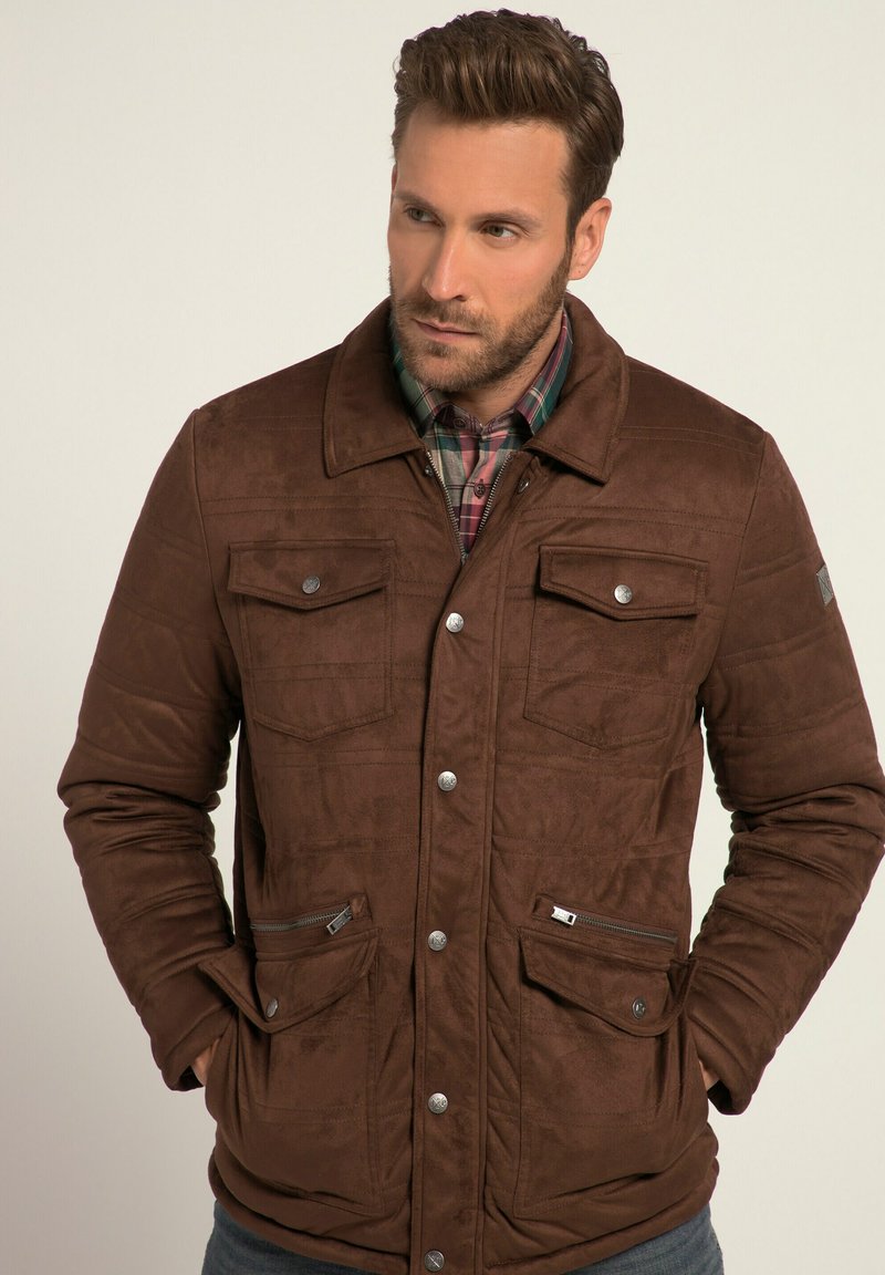 Brown suede jacket with quilted texture, snap closures, two chest pockets, and two side zippered pockets. Contrasting plaid shirt underneath.