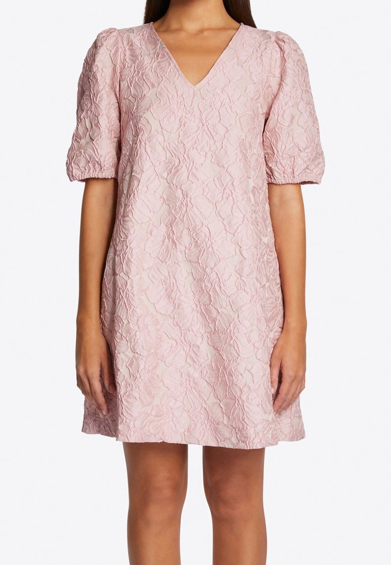 Różowa mini sukienka w kwiatowy wzór z dekoltem w kształcie litery V, krótkimi bufkami i teksturowanym materiałem. Szczegóły obejmują luźny krój i subtelny połysk.