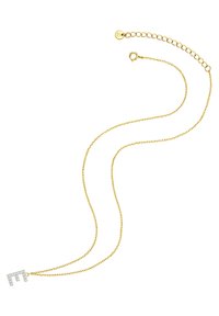 Auksinė grandinėlė su kampuota raidės "M" pakabučiu, papuoštu skaidriais kristalais, demonstruojanti subtilų ir elegantišką dizainą.