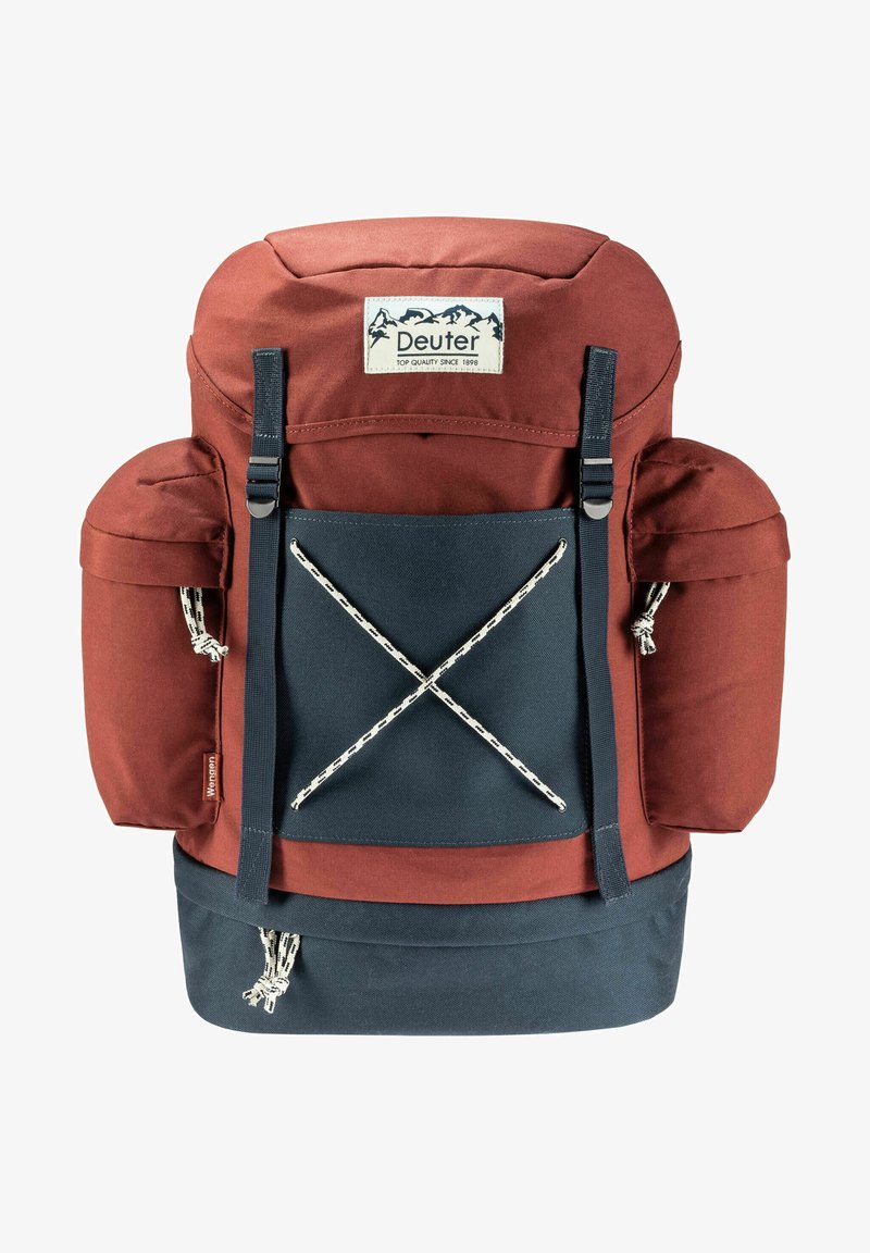 Rucksack in Rot und Marineblau mit gepolstertem Oberteil, zwei Seitenfächern und einem elastischen Befestigungssystem an der Vorderseite. Mit Markenetikett auf der Vorderseite.