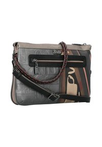 Bolso cruzado con patrones abstractos en negro y marrón, bolsillo con cremallera en el frente, detalle de asa trenzada y correa de cuero ajustable.