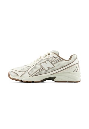 Witte en beige New Balance sportschoen met mesh bovenwerk, vetersluiting, gevoerde zool en bruine rubberen buitenzool, getoond in zijaanzicht.