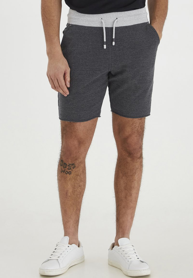 Dunkelgraue Sportshorts mit einem hellgrauen elastischen Bund, Kordelzugverschluss, Seitentaschen und einer strukturierten Oberfläche.
