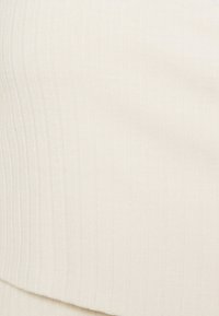 Weißes, geripptes Gewebe mit weicher Textur und horizontalen Linien. Das Gewebe wirkt glatt und gleichmäßig, mit einem dezenten Schimmer.