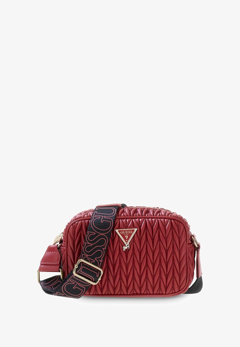 Czerwony pikowany crossbody z czarnym regulowanym paskiem, z logo marki "GUESS" oraz małym trójkątnym logo Guess z przodu.