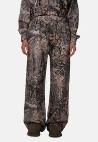 Camo-patroon broek in bruin- en grijstinten; losse pasvorm met een elastische tailleband en zakken; geschikt voor buitenshuis.