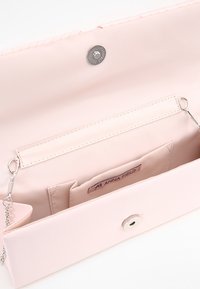 Jasnoróżowa kopertówka o gładkim wykończeniu, z zapięciem na klapkę i srebrnym zatrzaskiem. Wnętrze zawiera kieszonki na karty oraz łańcuszek.