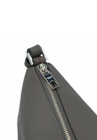Borsa in pelle grigia con angoli, dotata di zip in argento e cuciture di rifinitura. Presenta una texture liscia e una forma triangolare.