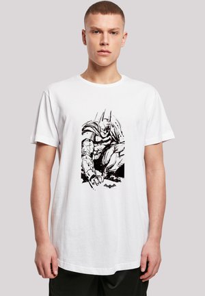 White cotton t-shirt featuring a black comic-style graphic of a crouching superhero. Short sleeves, round neck, relaxed fit.