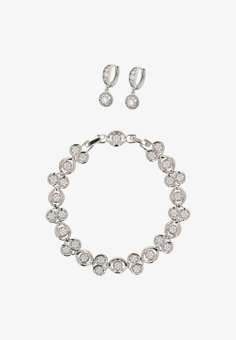 Srebrny komplet biżuterii z okrągłą bransoletką z kamieniami szlachetnymi i pasującymi kolczykami wiszącymi, ozdobiony błyszczącymi przezroczystymi kamieniami.