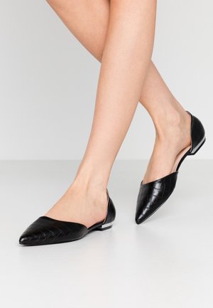 Czarne skórzane baleriny o plecionej fakturze, ze spiczastym noskiem, odkrytym tyłem i małym błyszczącym obcasem jako akcentem. Gładka powierzchnia i skrócony krój.