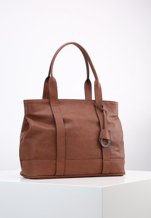 Brown leather tote bag with two sturdy handles, a front strap detail, and a circular metal accent. Smooth texture and structured shape.