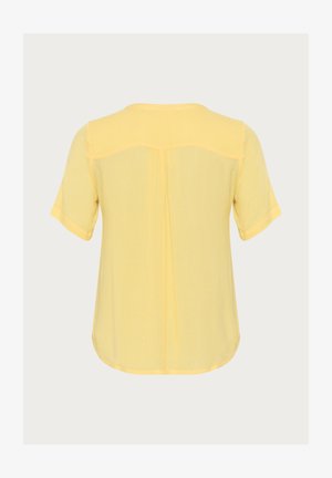 Haut jaune à manches courtes avec une coupe ample, présentant un col rond, un détail de plis au dos et un tissu doux et texturé.
