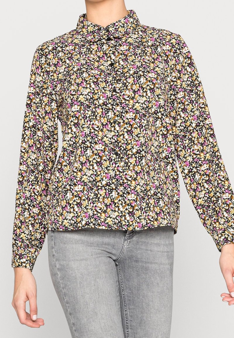 Blouse fleurie avec un fond noir orné de fleurs multicolores, patte de boutonnage à l'avant, manches longues et col classique.