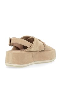 Sandales à plateforme en daim beige avec un large design à bandes croisées, une sangle arrière et un dessus texturé. La semelle est de couleur claire et épaisse.