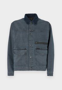 Denim jacket in dark blue with a contrast collar. Features large front pockets and a zippered chest pocket. Classic button closure.