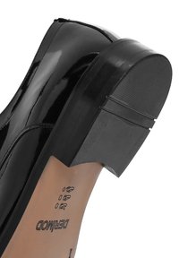 Chaussure en cuir verni noir avec un talon épais et une semelle texturée. Caractéristiques d'une finition lisse et de détails de couture sur le côté.