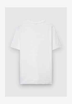 T-shirt blanc uni à manches courtes avec de subtiles rayures horizontales texturées, présenté de dos sur un fond neutre.