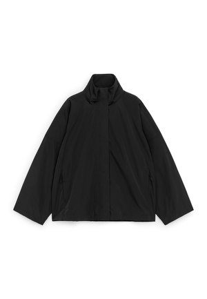 Sort letvægtsjakke med høj krave, lange vide ærmer og lynlås foran dækket af en klap, lagt fladt på hvid baggrund.