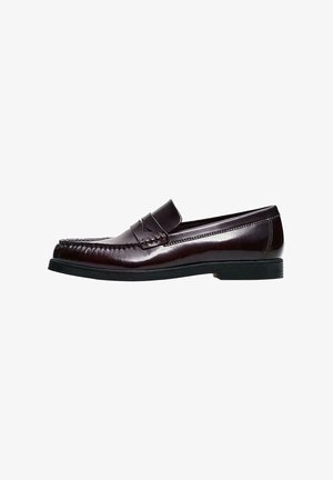 Donker bordeaux leren loafers met gestikte details en een decoratieve riem. Platte zwarte rubberen zool. Gladde, gepolijste oppervlak.