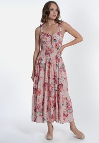 Abito maxi floreale in tessuto rosa con bustino aderente, fiocco decorativo e gonna a strati con volant; presenta spalline larghe e una stampa vivace.