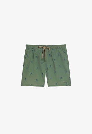 Bañador corto verde con cintura elástica, cordón beige, bolsillos laterales y un estampado de calaveras y huesos cruzados en azul.