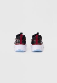 Black athletic shoes featuring a smooth fabric upper, red accents, and a white sole with a light blue tread. Plain background.