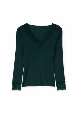 Dunkelgrünes Langarmshirt mit V-Ausschnitt und Spitzenbesatz entlang des Halsausschnitts und der Ärmelsäume auf weißem Hintergrund.
