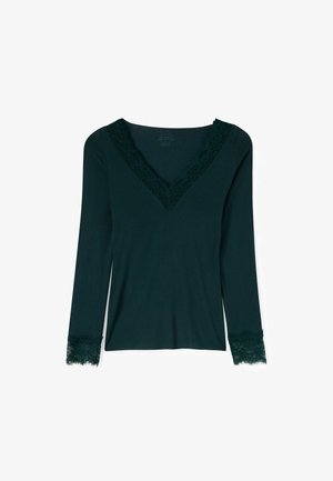 Dunkelgrünes Langarmshirt mit V-Ausschnitt und Spitzenbesatz entlang des Halsausschnitts und der Ärmelsäume auf weißem Hintergrund.