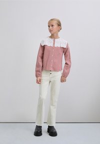 Red gingham button-up shirt with a white embroidered collar, paired with off-white straight-leg jeans and black platform boots.