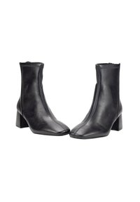 Botas de tobillo de cuero negro con punta cuadrada, tacón cuadrado, textura suave y costuras en los bordes, con un diseño que se ajusta ceñidamente.