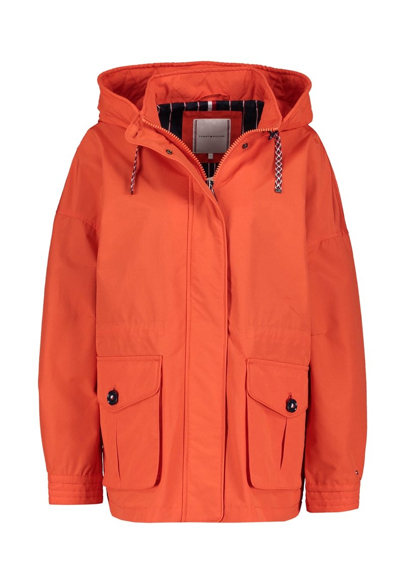 Giacca arancione con cappuccio, zip frontale, tasche a patta con bottoni e cappuccio regolabile con cordini neri e bianchi.