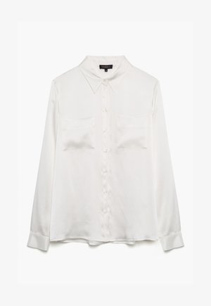 Witte blouse met lange mouwen van soepele stof, met een puntig kraag, knopen aan de voorkant en twee borstzakken. De manchetten zijn met knopen te sluiten.