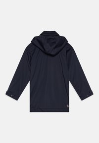 Navy waterproof jacket, featuring a hood, long sleeves, button cuffs, and a logo on the left hem. Smooth texture and lightweight design.