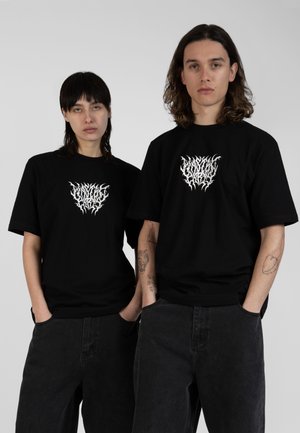 Black cotton t-shirts featuring a white graphic design on the front. The fabric is smooth, and the fit is relaxed, with short sleeves and a round neck.