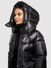 Zwarte pufferjas met een glanzende afwerking, grote capuchon, met ritsen afsluitbare zakken en een aansluitend model. Voorzien van trekkoordjes aan de capuchon.