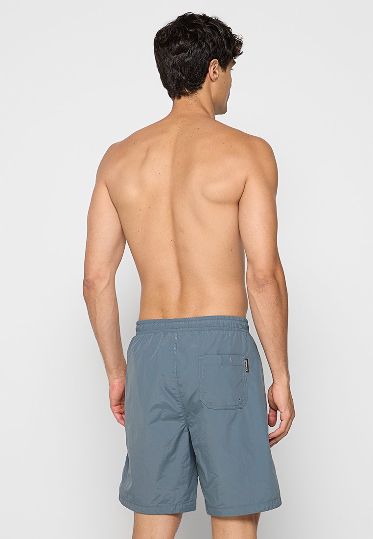 Grau Badehose aus leichtem Stoff. Elastischer Bund mit Kordelzug und eine Gesäßtasche mit rechteckigem Klappverschluss.